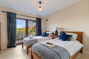 a bedroom with two beds and a large window at Glendale Saundersfoot in Saundersfoot +14 photos