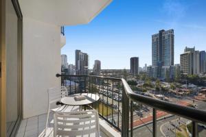 a balcony with a table and chairs and a city at Beautiful Studio Apartment with Ocean Views in Gold Coast