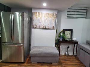 a kitchen with a stainless steel refrigerator and a chair at Luxurious Apt 2BRs-1BA Spacious Modern, with free parking in Brampton