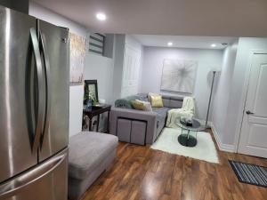 ein Wohnzimmer mit einem Kühlschrank und einem Sofa in der Unterkunft Luxurious Apt 2BRs-1BA Spacious Modern, with free parking in Brampton