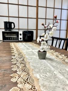 a table with a vase with flowers on it at 四ツ木駅徒歩2分リノベーション済み家具家電無料WiFi完備スカイツリー電車5分 in Tokyo
