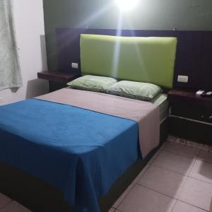 1 dormitorio con 1 cama con manta azul y verde en Chambres en Ville en David