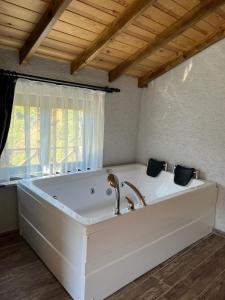 a large white bath tub in a room with a window at Gülhan Butik Hotel & Bungalov in Rize