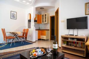 ein Wohnzimmer mit einem TV und einem Tisch in der Unterkunft Apartments with a parking space Vodice - 22290 in Vodice
