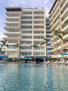 un grande edificio con piscina di fronte a un hotel di Casa Cielo Vallarta V-Golf a Puerto Vallarta