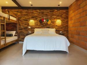a bedroom with a bed and a brick wall at Gulupa Ecolodge in Jardin