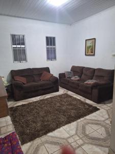 uma sala de estar com dois sofás castanhos e um tapete em Chácara Deh* em Bragança Paulista