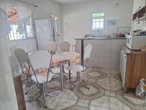 Chácara Deh* في براغانكا باوليستا: مطبخ مع طاولة وكراسي وثلاجة