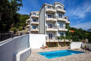 a building with a swimming pool in front of a building at Boka Vista Sea View & Swimming pool in Kamenari