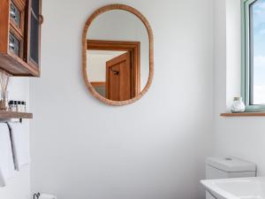 a bathroom with a mirror on the wall at Norville Lodge in Heathfield
