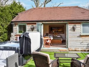 een klein huis met een tuin en een patio bij Norville Lodge in Heathfield