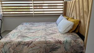 a bed in a bedroom with a pillow and a window at Departamento en mazatlan bluue Lagoons in Mazatlán