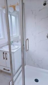 uma casa de banho branca com um chuveiro e um lavatório. em 3bed 1 bath suite - Surrey Fleetwood em Surrey