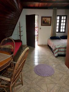 a bedroom with a bed and a table and chairs at Chalé Pousada em Salesopolis 7 in Salesópolis