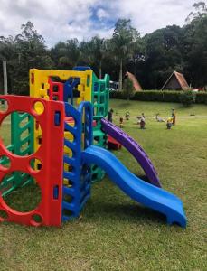 a playground with colorful play equipment in a field at Chalé Pousada em Salesopolis 7 in Salesópolis