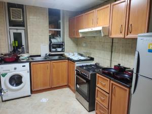 cocina con armarios de madera y horno con fogones en Arnim Suite - 3 Bedrooms Apartment, en Sharjah