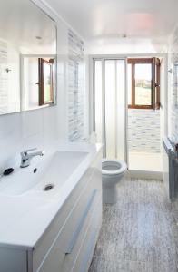 Baño blanco con lavabo y aseo en AG Casa Vilamar en primera linea de playa Razo, en Razo da Costa