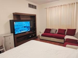a living room with a couch and a flat screen tv at Arnim Suite - 3 Bedrooms Apartment in Sharjah