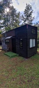 a black tiny house sitting on top of a yard at Tiny house Alto bosque in Pucón