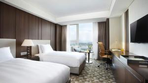 a hotel room with two beds and a television at LOTTE City Hotel Daejeon in Daejeon