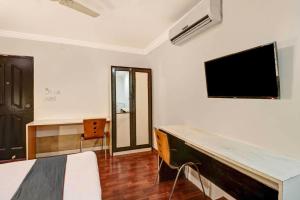 a bedroom with a bed and a tv on the wall at Sabharwal Residency Near Lalbagh Botanical Garden in Bangalore