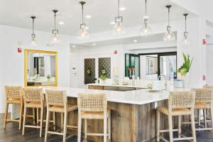 a kitchen with a large white counter and chairs at CozySuites at Kierland Commons by golf course! in Scottsdale