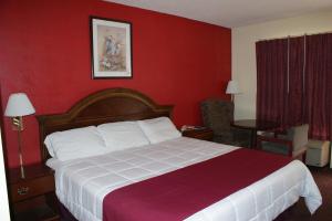 Habitación de hotel con cama y pared roja en The Patriot Inn, en Register