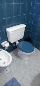 a blue tiled bathroom with a toilet and a sink at La verde de Playa in Playa Unión
