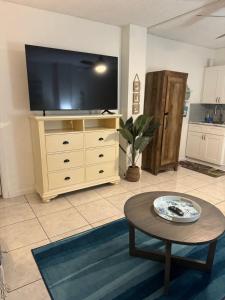 a living room with a large television on a dresser at Direct ocean front view 1 bedroom working pool in Daytona Beach