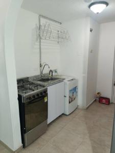 uma cozinha com um fogão e um lavatório em Bonito aparta estudio central em Bogotá
