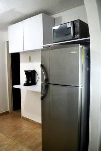 uma cozinha com um frigorífico de aço inoxidável e um micro-ondas em Bonito aparta estudio central em Bogotá