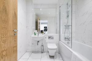 een witte badkamer met een toilet en een wastafel bij Apollo Luxury - Netflix - Fast WIFI- FREE PARKING in Birmingham