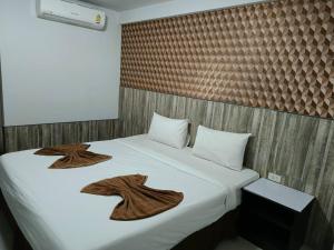 a bedroom with a bed with towels on it at Grand Pruksa Siri Apartment in Sara Buri