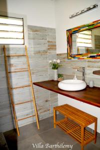 ein Bad mit einem Waschbecken und einem Spiegel in der Unterkunft Villa Barthélemy in Goyave