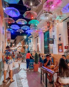 un gruppo di persone seduti ai tavoli sotto gli ombrelloni di DUSANO BOUTIQUE HOTEL a Santa Marta