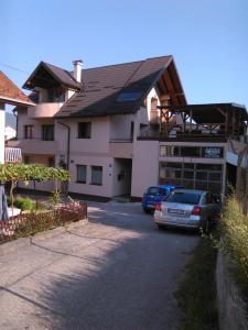 a house with two cars parked in front of it at Apartment Dimitrieski in Višegrad