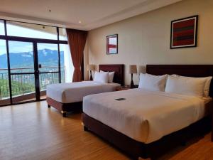 a hotel room with two beds and a balcony at Alvea Hotel and Residences in Baguio