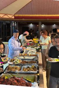 una línea de buffet con muchos platos de comida. en Rum Legend camp en Wadi Rum