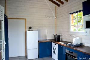 eine Küche mit blauen Schränken und einem weißen Kühlschrank in der Unterkunft Villa Barthélemy in Goyave