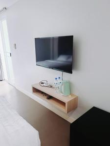 a flat screen tv on a wall in a room at Mitr Inn Mrt Samyot Station - The Grand Palace in Bangkok