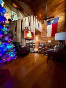 a living room with a christmas tree and a tv at The Cedar House - Huntsville Cultural District in Huntsville
