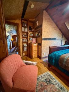 a bedroom with a bed and a chair in a room at The Cedar House - Huntsville Cultural District in Huntsville