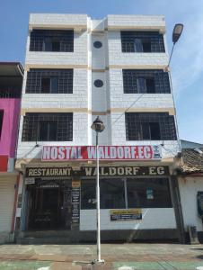 un edificio con un cartel en la parte delantera en HOSTAL WALDORF.EC en Baños