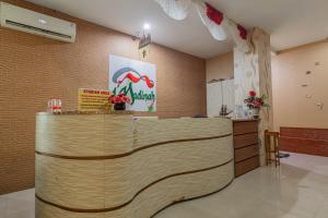 a lobby with a wooden counter in a room at Hotel DMadinah inn Gentan in Solo