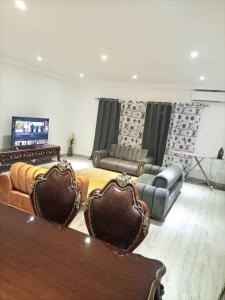 uma sala de estar com sofás e uma televisão de ecrã plano em Appartement bord de mer em Ponta Negra