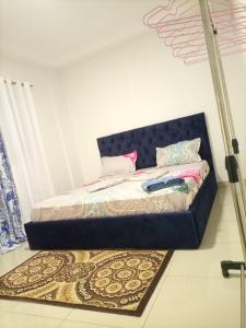 - un lit dans une chambre avec un tapis au sol dans l'établissement Appartement bord de mer, à Pointe-Noire