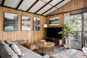 un soggiorno con divano e TV di Secluded Cabin Hot Tub, Huge Deck, Fire Pit, WiFi a Hedgesville