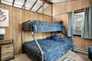 una camera con un letto in una stanza con pareti in legno di Secluded Cabin Hot Tub, Huge Deck, Fire Pit, WiFi a Hedgesville
