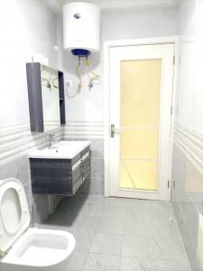 łazienka z toaletą, umywalką i drzwiami w obiekcie Appartement bord de mer w mieście Pointe-Noire