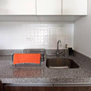 a kitchen sink with an orange towel on it at Apartamento con increíble vista al mar in Lima